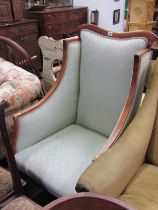 EDWARDIAN MAHOGANY FRAMED WING ARMCHAIR on short cabriole legs and original castors