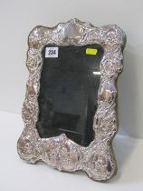 ORNATE SILVER EASEL PICTURE FRAME, decorated putti heads in relief, 33cms height
