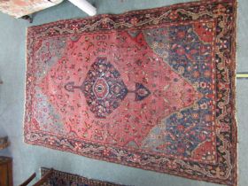 EASTERN HAND KNOTTED CARPET, with central blue stylised motif on a pink ground within 3 main