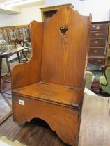 ANTIQUE ELM CHILD'S ROCKING CHAIR, rising seat encloses a commode base, 70cm height