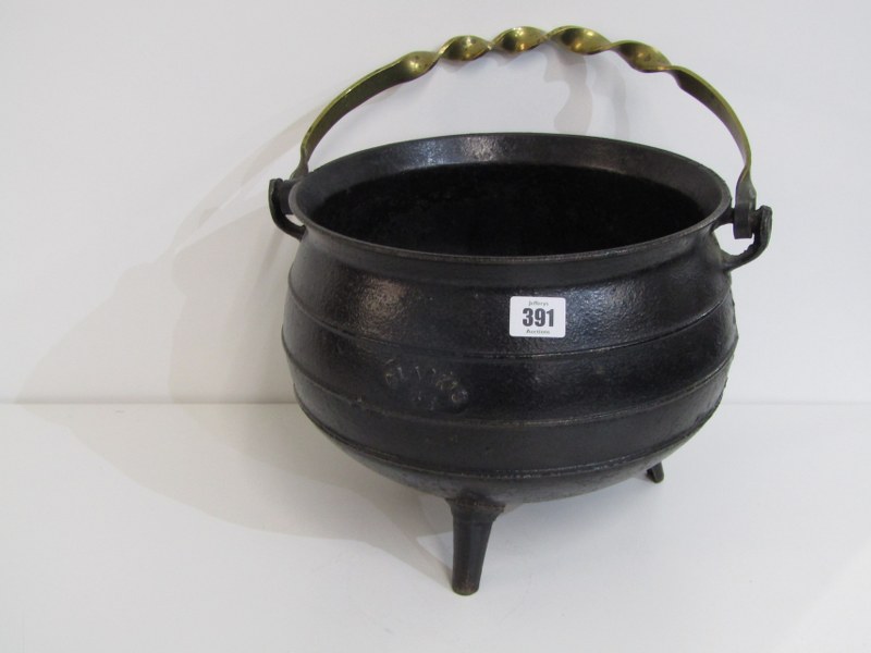 IRON CAULDRON, Clarks iron cauldron on 3 feet, with ornate brass handle, 33cm diameter