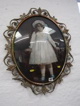 PAINTING ON GLASS, oval portrait of a Victorian girl 48cms in a brass foliate frame