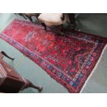 CAUCASIAN RUNNER RUG, decorated medallions on a red ground with blue borders, 300cm x 86cm