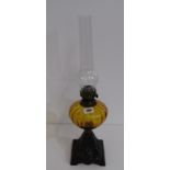 EDWARDIAN OIL LAMP with cast iron floral decorated base, amber glass reservoir and chimney, 53cm