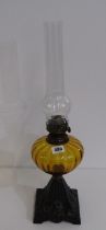 EDWARDIAN OIL LAMP with cast iron floral decorated base, amber glass reservoir and chimney, 53cm