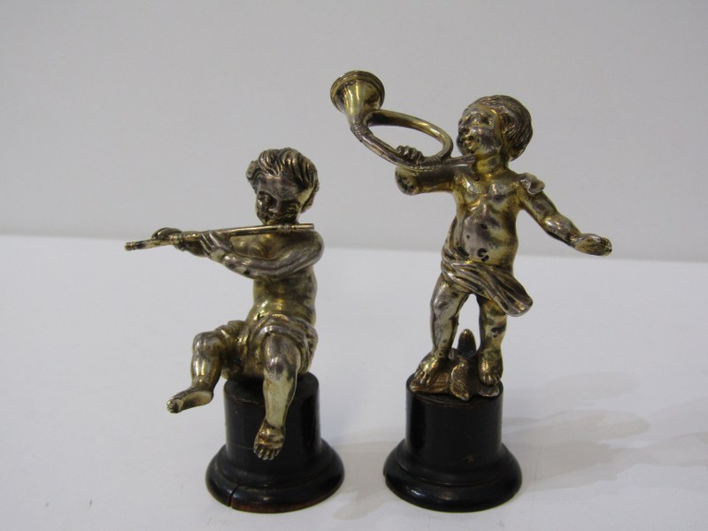 PAIR OF SILVER GILT PUTTI MUSICIANS on circular ebonised wood bases, 9cm height, bases a/f