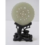 CHINESE JADE, carved Chinese jade disc, 5.5cm diameter on an intricate carved hardwood stand