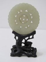CHINESE JADE, carved Chinese jade disc, 5.5cm diameter on an intricate carved hardwood stand