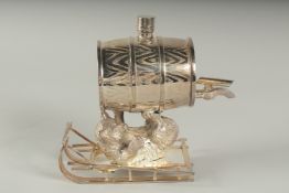 A SILVER PLATED BEAR ON A SLEDGE with a barrel.