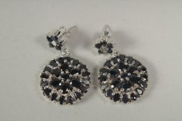 A pair of silver real sapphire cluster earrings in a box.