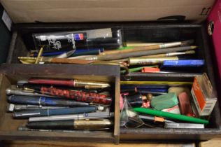 An old wooden cutlery box containing numerous pens etc.