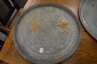 An Islamic circular brass tray with engraved decoration.