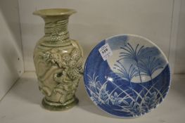 A small Chinese circular blue and white bowl and an incised celadon glazed vase.