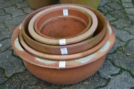 A collection of terracotta circular planters.