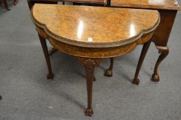 A good burr walnut fold-over card table of shaped outline on carved cabriole legs with claw feet.
