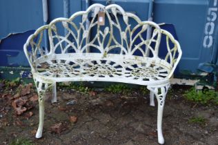 A small white painted cast metal garden bench.