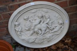 A classical style oval wall plaque moulded with cherubs and a lion.