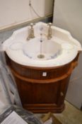 A Victorian style porcelain corner wash basin with mahogany vanity unit.