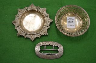 Two small silver dishes and an engraved silver buckle.