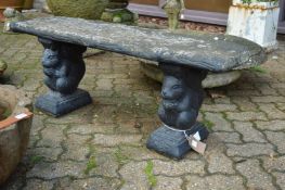 A reconstituted stone garden bench with squirrel supports.