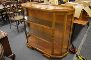 An Art Deco walnut bookcase with three pairs of sliding glass doors.