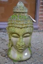 A reconstituted stone garden ornament modelled as the head of a Buddha.