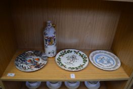 Decorative plates and an armorial wine flask.