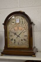 A mahogany cased mantle clock with engraved silvered dial.