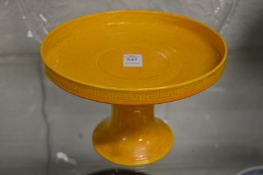 A Chinese yellow glazed pedestal stand with incised decoration.