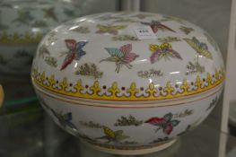 A large Chinese circular bowl and cover decorated with butterflies.