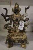 An Eastern carved metal figure of a multi-arm deity.