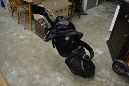 A bag of golf clubs with folding stand.