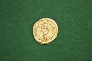 A gold coin, possibly a Byzantine Solidus together with two other coins.