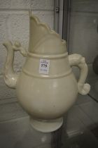 A large pale celadon glazed Chinese ewer.