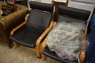 A pair of cantilever style black leather upholstered armchairs.