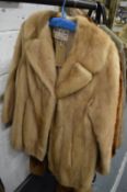 A ladies fur jacket and two fur coats.