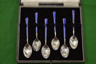 A cased set of six silver and enamel coffee spoons.