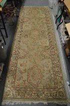 A Persian design rug, cream ground with stylised decoration (worn) 280cm x 95cm.