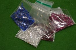 Various bags of coloured spinels.
