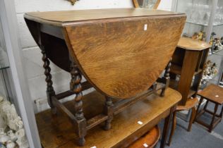 An oak drop leaf gateleg dining table with barley twist supports.