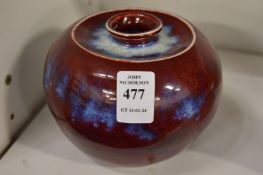 A Chinese flambe glazed squat shaped circular vase.