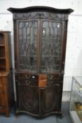 A Neo-Classical revival mahogany serpentine fronted cupboard bookcase with pair of astragal glazed