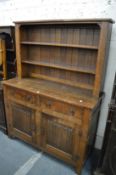 An oak dresser with two drawers and linen fold decorated doors.