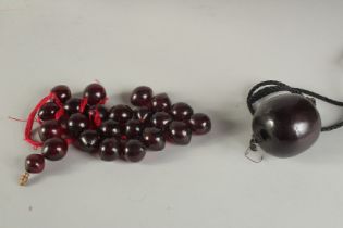 A LARGE TURKISH OTTOMAN CHERRY AMBER BEAD, together with a collection of cherry amber beads, large