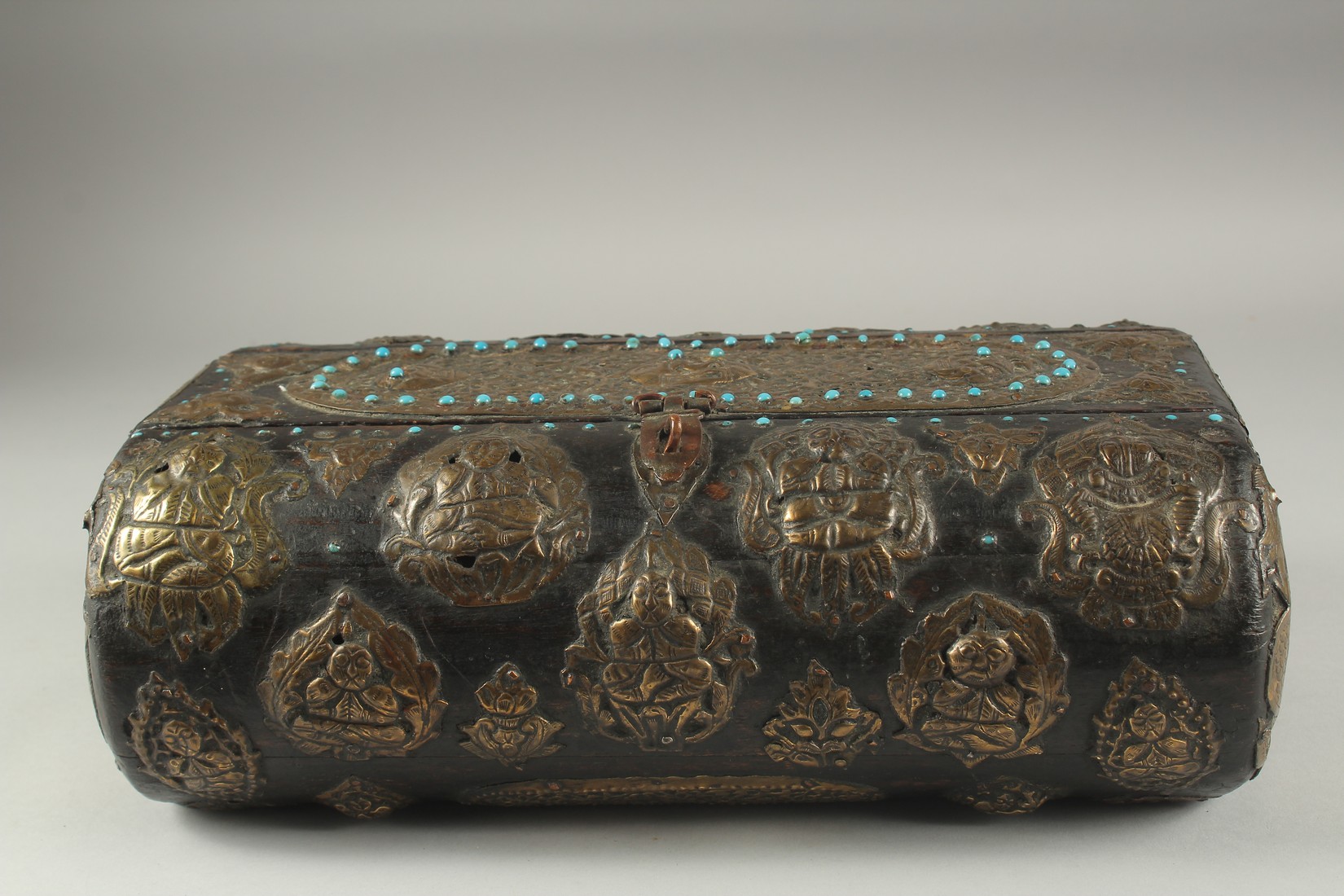 A TIBETAN TURQUOISE INSET BRASS MOUNTED WOODEN BOX, 35cm x 21cm.
