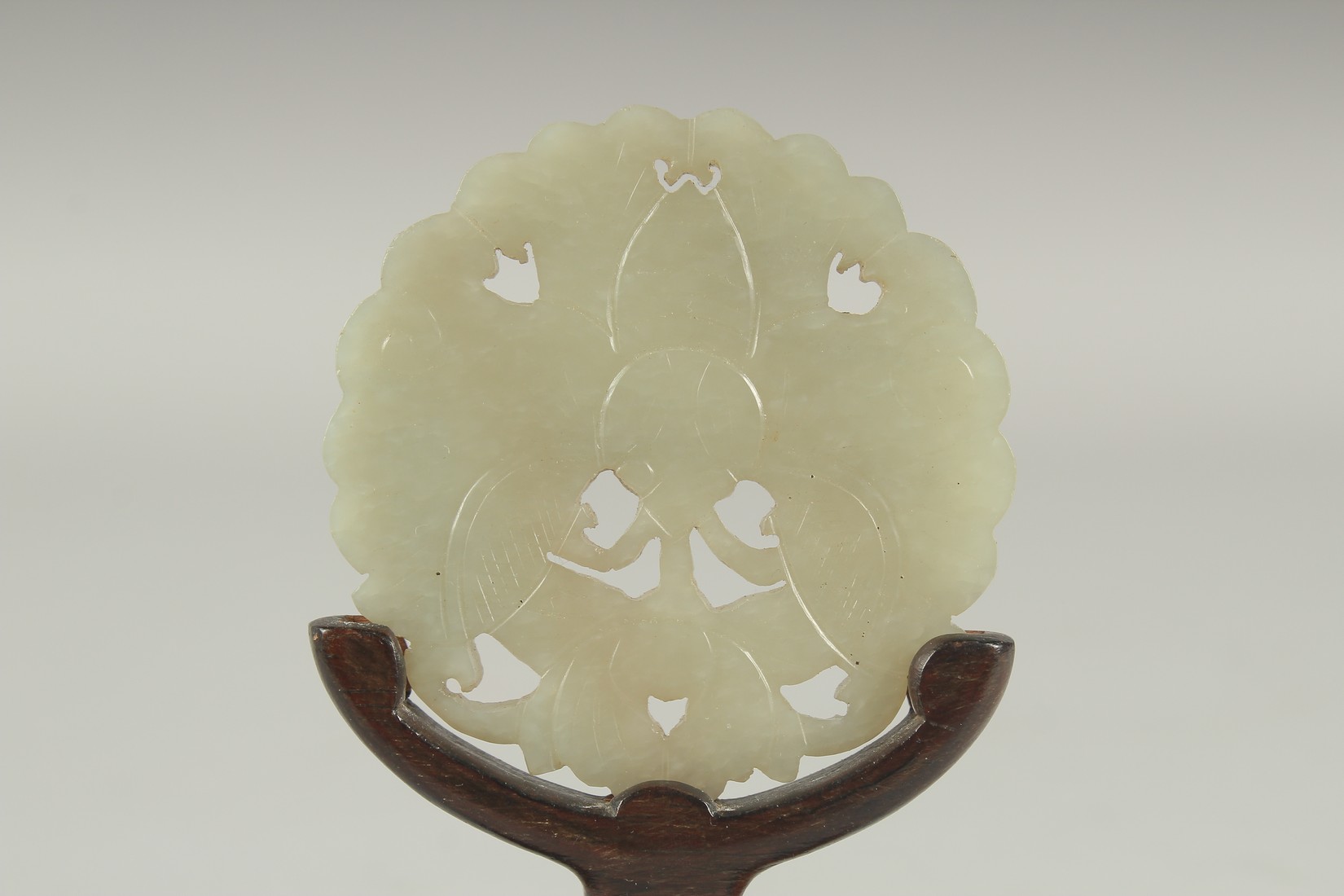 A CHINESE CARVED AND PIERCED JADE MOTH AMULET, on a fitted wooden stand, 6cm diameter. - Image 2 of 3