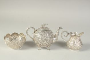 AN INDIAN EMBOSSED AND CHASED SILVER TEA SET, (3).