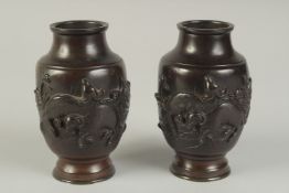 A PAIR OF JAPANESE BRONZE VASES, relief decorated with rams and flora, 13.5cm high.