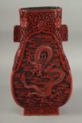 A CHINESE CINNABAR LACQUER TWIN HANDLE DRAGON VASE, with four panels of finely carved dragons
