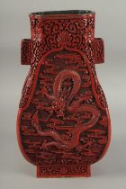 A CHINESE CINNABAR LACQUER TWIN HANDLE DRAGON VASE, with four panels of finely carved dragons